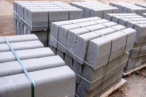 Stack of packed border stones for asphalt road on wooden pallet Stock Photos