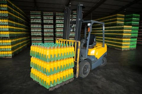 Stack of packed juice bottles and forklift 写真素材