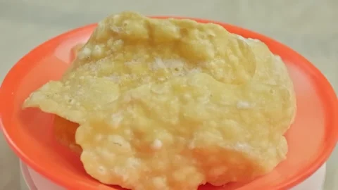 Stack of pale yellow sweet crackers on a rotating orange plate Stock Footage 323572180