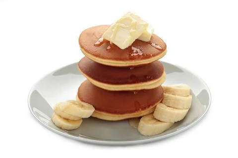 Stack of pancakes with banana slices isolated on white Stock Photos