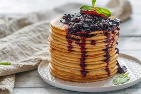 Stack of pancakes with berry sauce. Stock Photos
