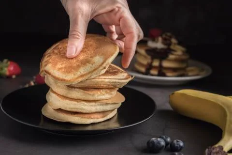 Stack of pancakes on a black plate. Stock Photos