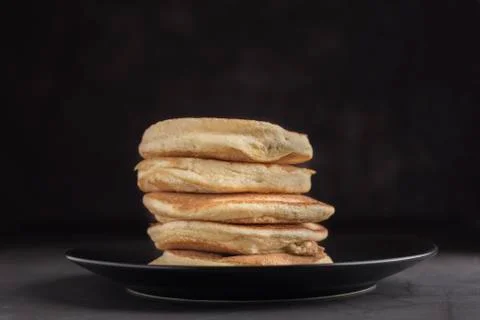 Stack of pancakes on a black plate. Stock Photos