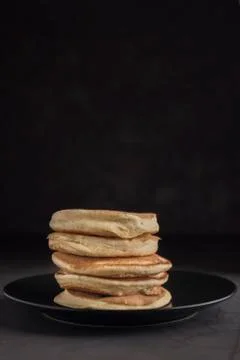 Stack of pancakes on a black plate. Stock Photos