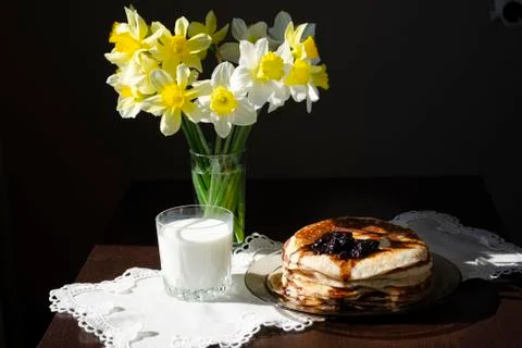 Stack pancakes with blackcurrant jam in plate on black table, delicious desse Stock Photos