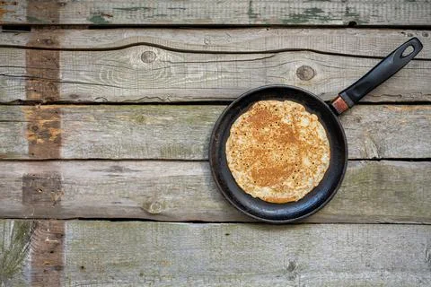 Stack of pancakes on a cast-iron frying pan on a wooden table . Top view. Flat Stock Photos
