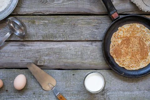 Stack of pancakes on a cast-iron frying pan on a wooden table . Top view. Flat Stock Photos