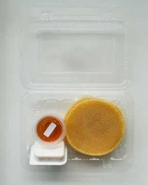 Stack of pancakes in a container transparent clear box with honey and butter  스톡 사진