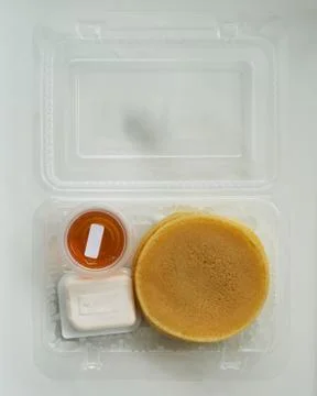 Stack of pancakes in a container transparent clear box with honey and butter  스톡 사진
