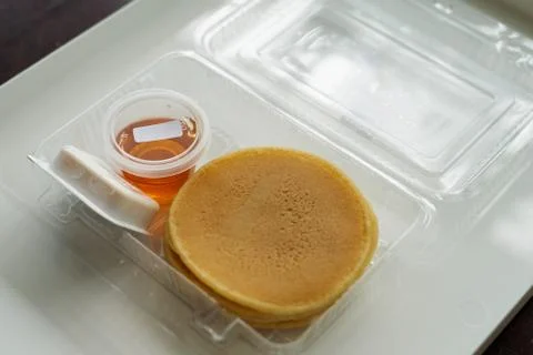 Stack of pancakes in a container transparent clear box with honey and butter  스톡 사진