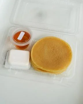 Stack of pancakes in a container transparent clear box with honey and butter  스톡 사진