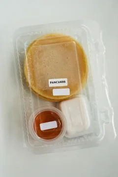 Stack of pancakes in a container transparent clear box with honey and butter  스톡 사진