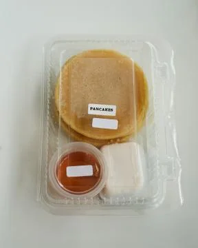 Stack of pancakes in a container transparent clear box with honey and butter  Foto stock