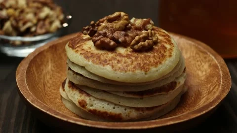 A stack of pancakes with crushed walnuts dripped with honey close up Stock Footage 170717531