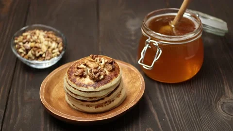 A stack of pancakes with crushed walnuts dripped with honey Stock Footage 170717684