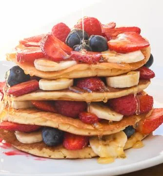 Stack of Pancakes with Fresh Berries and Bananas Фото