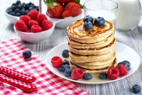 Stack of pancakes with fresh blueberry, raspberry and honey, milk and berries Stock Photos