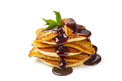 Stack of pancakes with fried banana, mint leaf and chocolate syrup on white Stock Photos