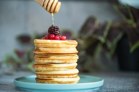 Stack of pancakes with honey stick Stock Photos