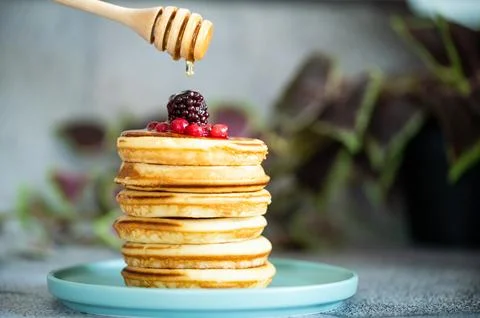 Stack of pancakes with honey stick Stock Photos