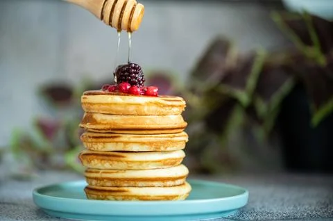 Stack of pancakes with honey stick 스톡 사진