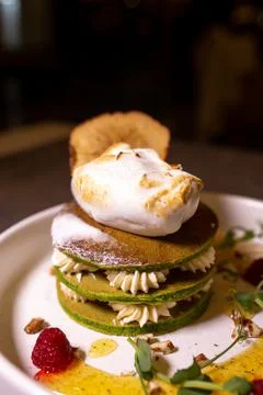 A stack of pancakes with matcha tea served in a plate on the table in a resta Stock Photos