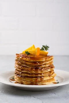 Stack of pancakes with with orange and sprinkled caramel  syrup Stock Photos