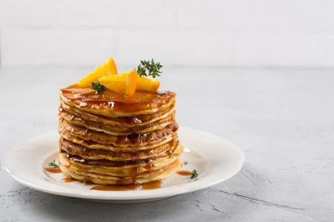 Stack of pancakes with with orange and sprinkled caramel  syrup Stock Photos