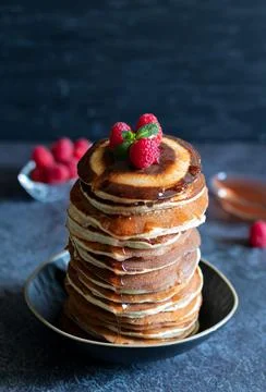 Stack of pancakes with raspberrie and maple syrup on dark background Stock Photos