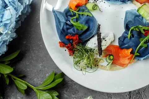A stack of pancakes with salted salmon on a plate. Blue pancakes with salmon Stock Photos
