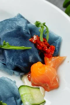 A stack of pancakes with salted salmon on a plate. Blue pancakes with salmon Stock Photos