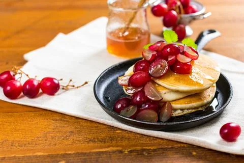 Stack of Pancakes with Sliced Red Grapes and Maple Syrup 스톡 사진