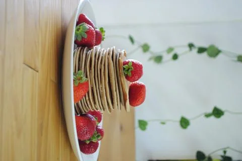 Stack of pancakes with some organic and fresh strawberries with some green pl Stock Photos