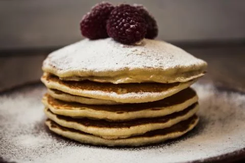 Stack of pancakes with sugar powder and raspberry Stock Photos