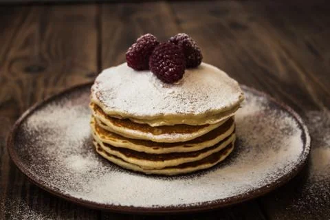 Stack of pancakes with sugar powder and raspberry Stock Photos