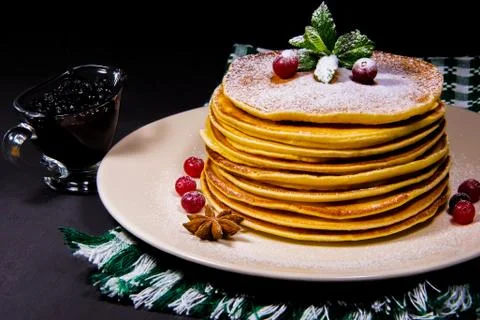 Stack of Pancakes on a white plate with green wipe cranberry puddings and cin Stock Photos