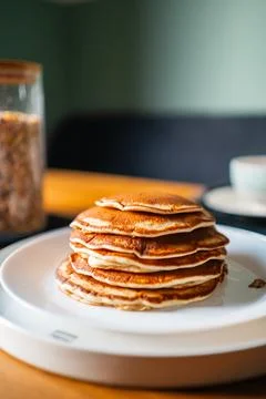 Stack of Pancakes on a White Plate Standing on a Wooden Breakfast Table Stock Photos