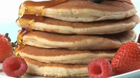 A stack of pancaks being dizzled with maple syrup Stock Footage 8574864