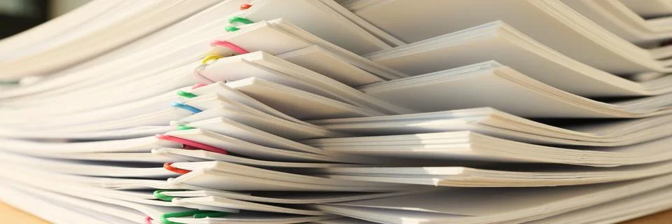 A stack of paper with colored paper clips, close-up Stock-Fotos