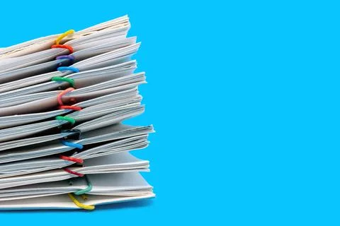 A stack of paper with colored pins on a blue background. Paper 写真素材