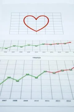 Stack of paper documents with financial reports and a big red heart isolated  Stock Photos