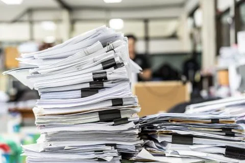 The stack of paper lay on a messy office table. Stock Photos