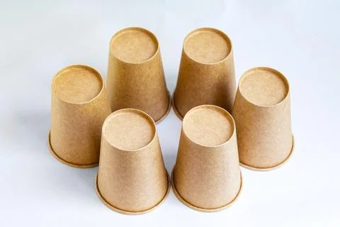 Stack of paper mugs. Six disposable paper cups made of cardboard kraft paper. Stock Photos