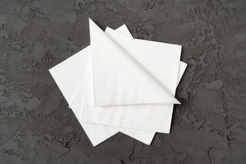 Stack of paper square napkins on gray background Foto stock