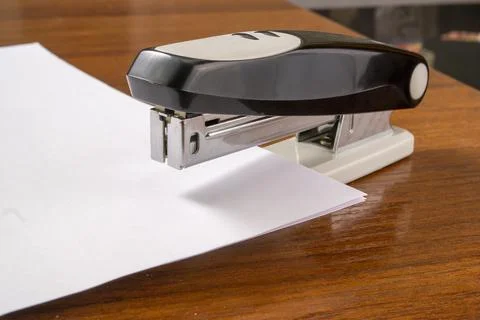 A stack of paper is stapled together with a stapler Stock Photos