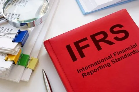 A stack of papers and a book IFRS International Financial Reporting Standards. Stock Photos