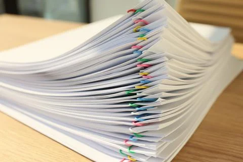 Stack of papers fastened with pins lies on wooden table 스톡 사진