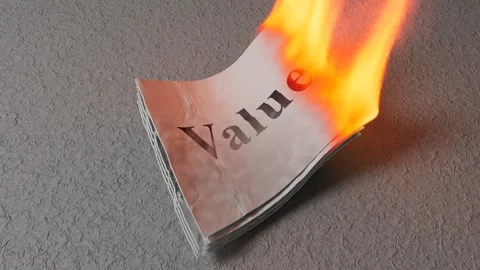 Stack of papers labeled Value burning representing economic destruction 库存影片 332748512