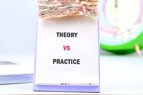 A stack of papers shows the words theory and practice, highlighting their dis Stock Photos