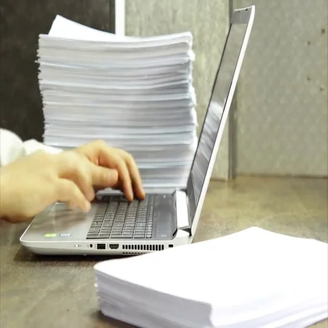 Stack of papers, working on laptop with document Stock Footage 69466607